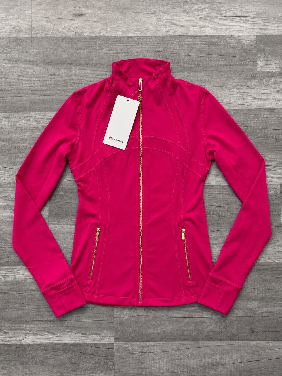Pink jacket with a tag on a gray wooden surface